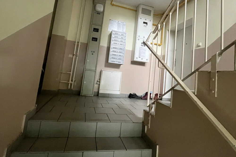 Klatka schodowa przed remontem ze starą posadzką i beżową lamperią