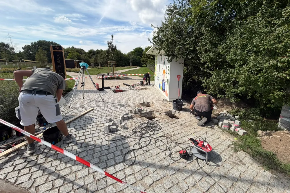 Prace ziemne i miejscowo rozebrana nawierzchnia z kostki przy książkomacie w Parku Literackim